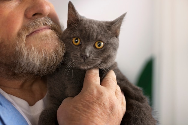 Free photo old man holding cat side view