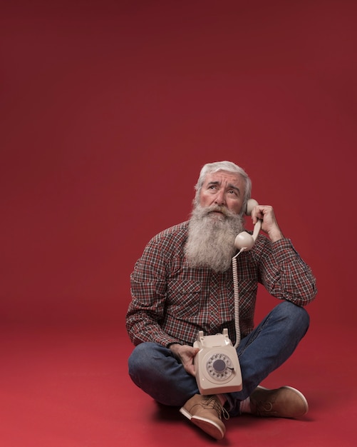 Free Photo old man holding a telephone