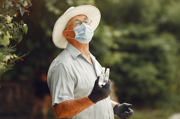 Old man in a medical mask. Man in the park. Coronavirus theme.