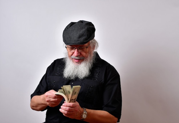 An old man with a beard counting his money