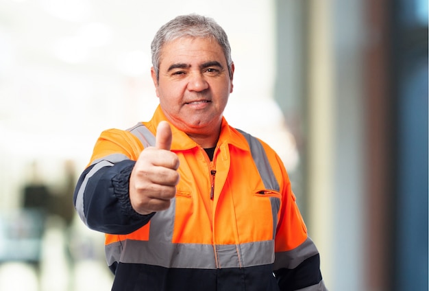 Old man with a reflective suit with thumb up