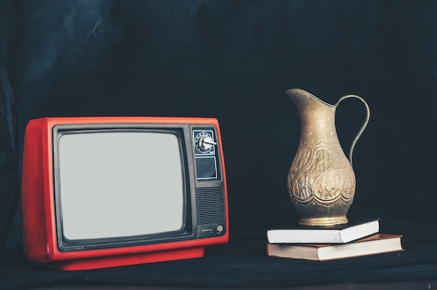 Free photo old retro tv by placing flower vases on books