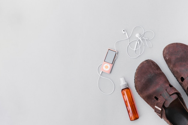 An old rustic shoes with perfume bottle and mp3 player with earphone