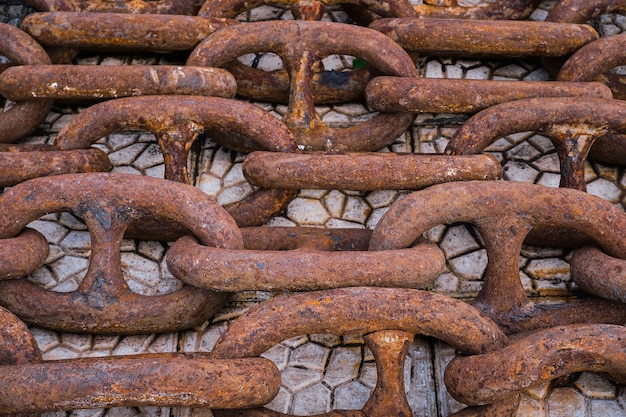 Free photo old rusty ship's chain on the pier top view idea for the background the concept of shipping and recycling of materials