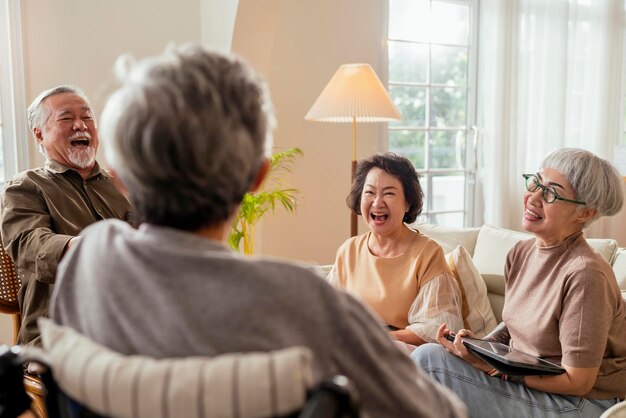 Old senior asian friends retired people hapiness positive laugh smile conversation together at living room at nursing home Seniors participating in Group Activities in Adult Daycare Center