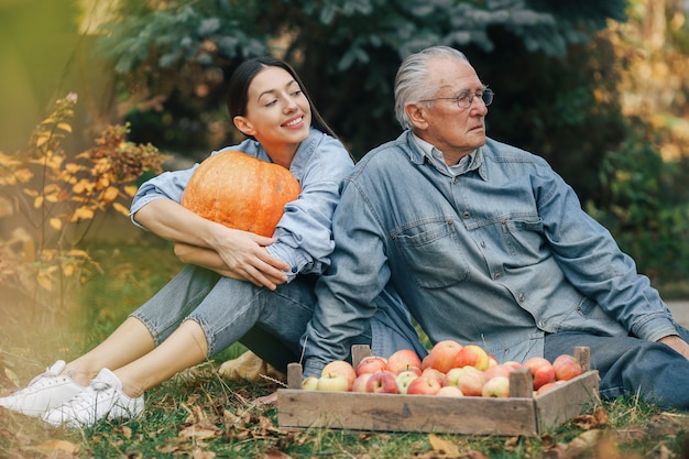 Old senior in a summer garden with granddaughter