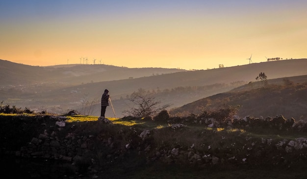 Old shepherd looking to the mountains at sunset