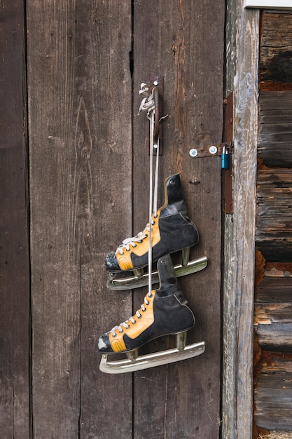 Free photo old skates hanging on wood door