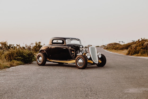 Old vintage car parked in the middle of the freeway road