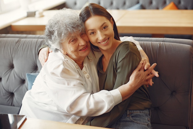 Old woman in a cafe with young granddaughter