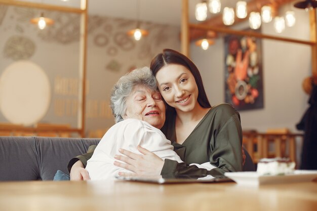 Old woman in a cafe with young granddaughter