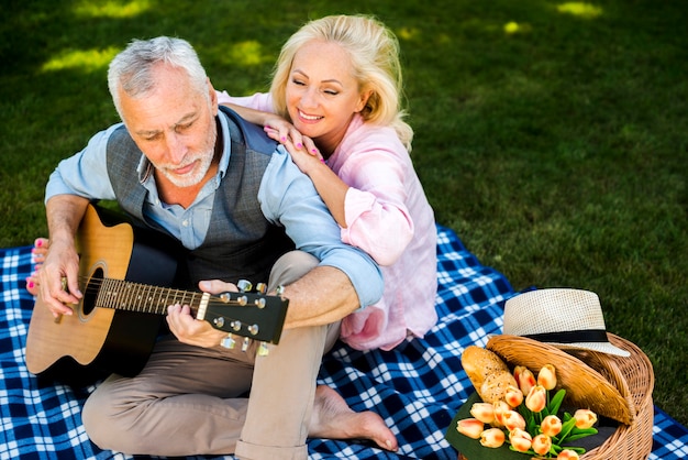 Free photo old woman enjoying her man guitar song