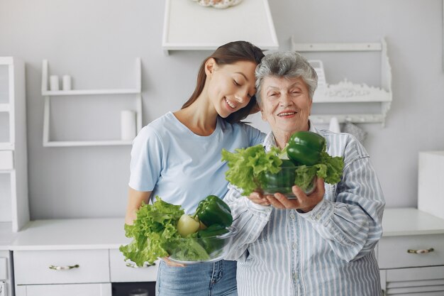 Old woman in a kitchen with young granddaughter