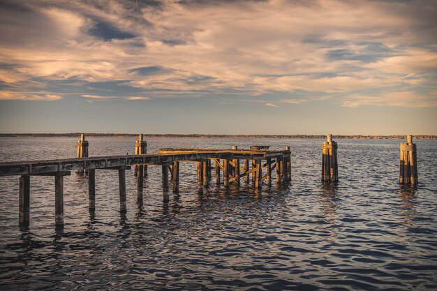 Old wooden dock on the sea under the sunlight during the sunset