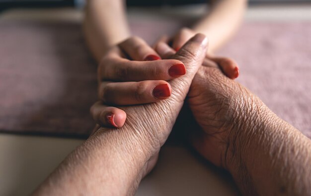 Old and young man holding hands close up