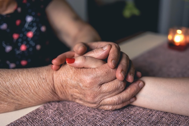 Old and young man holding hands close up