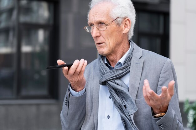 Older casual man in the city talking on smartphone