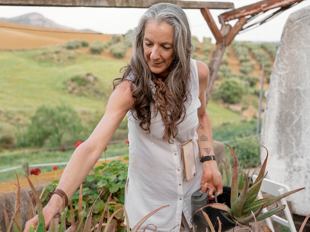 Older female farmer watering her plants