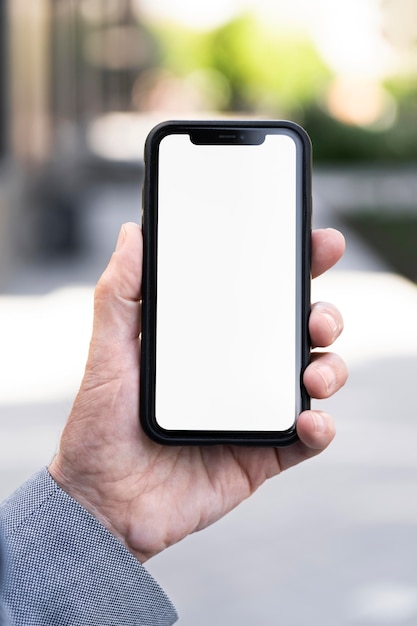 Older man in the city holding smartphone