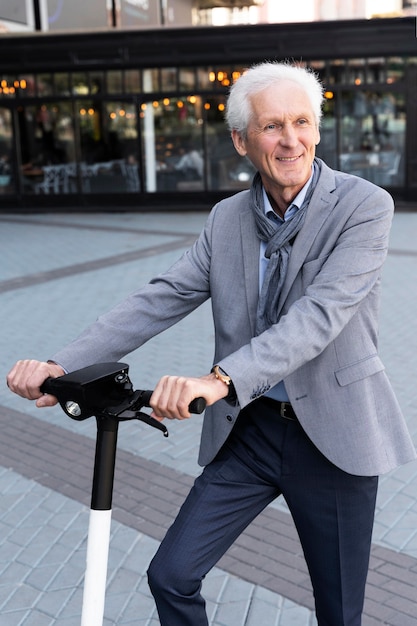 Older man in the city with  electric scooter