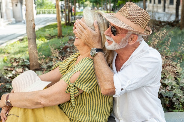 Free photo older man covering the woman's eyes with her palms