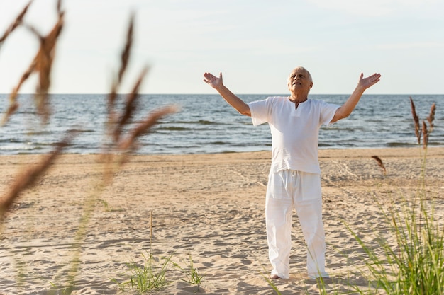 Free Photo older man enjoying his time outdoors at the beach