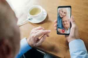 Free photo older man talking to his friends through a video call