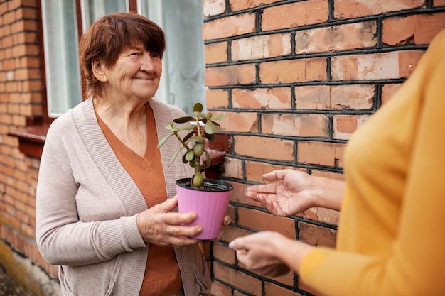 Free photo older person offering gift to neoghbor