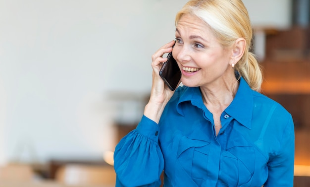 Older woman talking on the phone while working