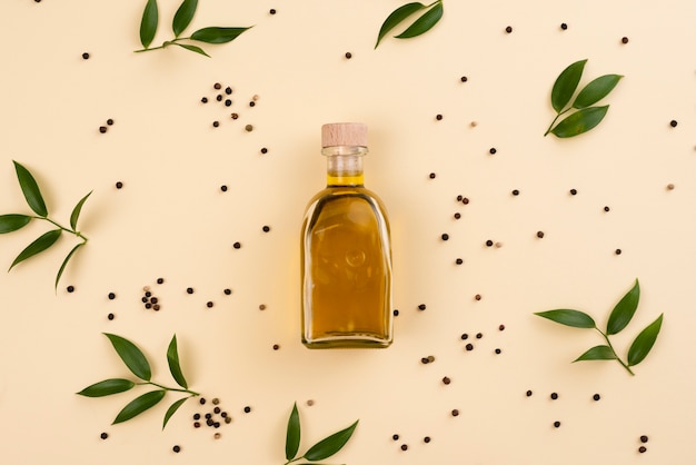 Olive oil bottle surrounded by olive leaves