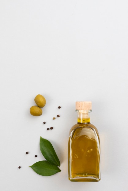 Free photo olive oil bottle on table with copy-space