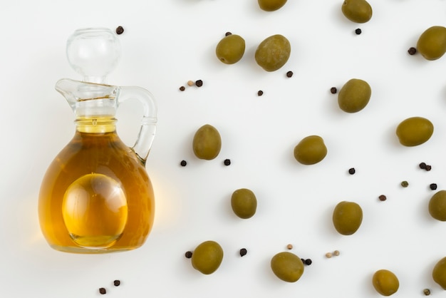 Free photo olive oil bottle with olives next