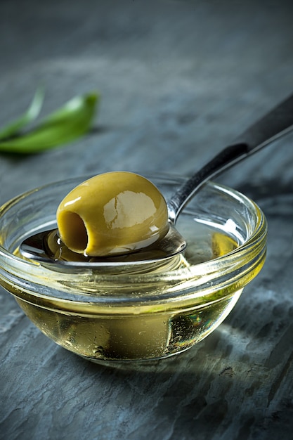 Olive oil and olive branch on the wooden table