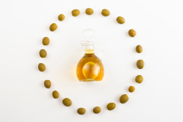 Free photo olives circle shape surrounding olive oil bottle