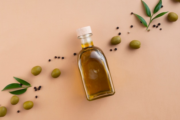 Free photo olives oil bottle with spead olives and leaves next