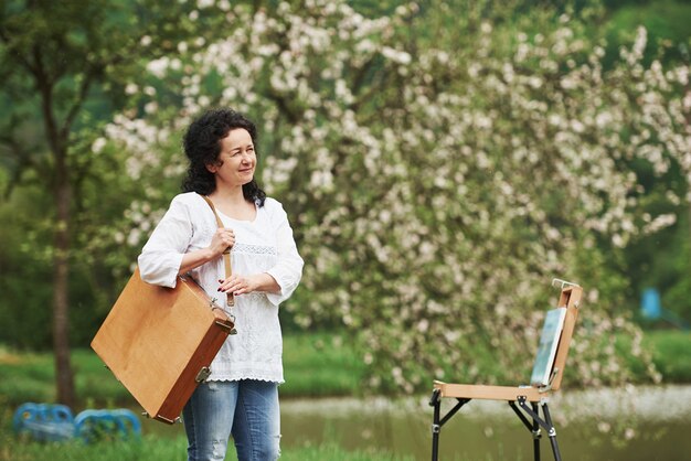 One person only. Mature painter with case of instruments have a walk in the beautiful spring park