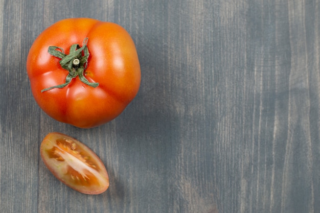 One whole juicy tomato on a wooden table