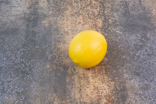 Free photo one whole lemons on stone surface