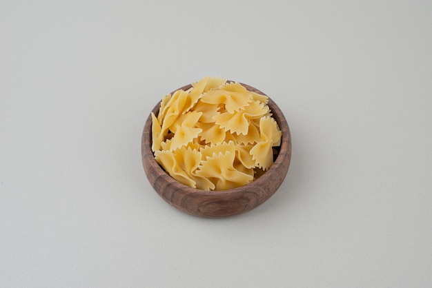 One wooden bowl full of raw macaroni