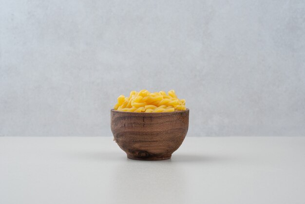 One wooden bowl full of raw macaroni