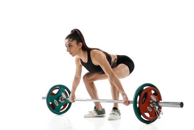 One young strong female weightlifter workout with a weight barbell isolated on white background Sport weightlifting concept