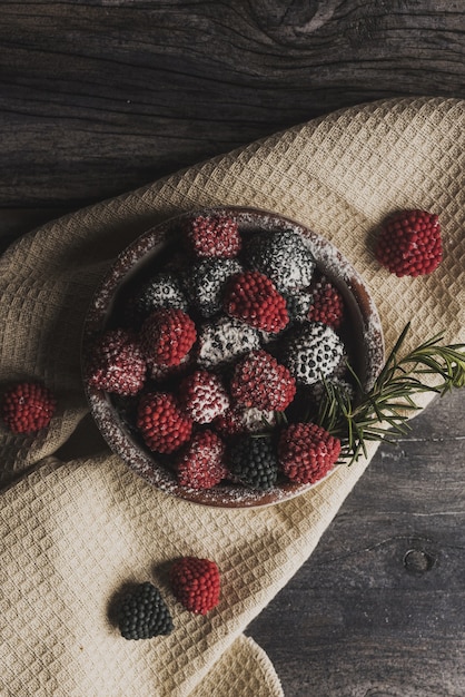 Free photo onhead shot of the fresh berries on a kitchen towel poured with sugar powder