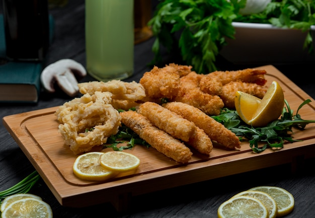 Onion circles and chicken roasted sticks served with lemon slices