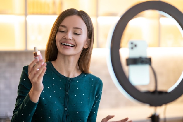 Online presentation. Young woman representing new facial cream and looking involved