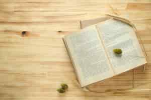 Free photo open book with ears of corn on a wooden background