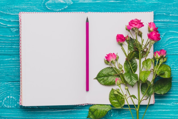 Free Photo open book with pencil and purple flowers