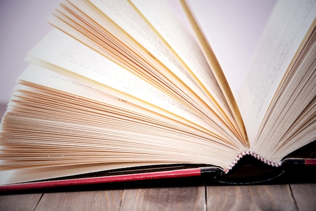 Open book on wooden table.