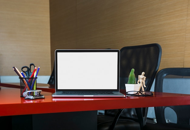 An open laptop with stationeries on office desk in the office