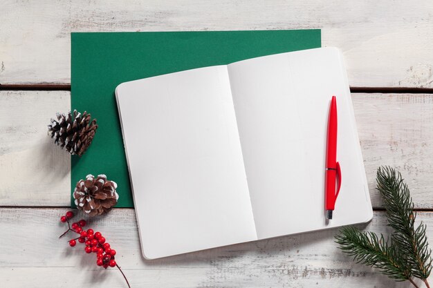 The open notebook on the wooden table with a pen