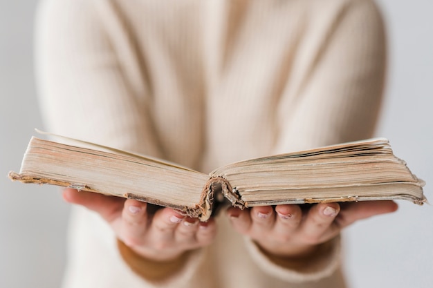 An open old book in the woman's hand